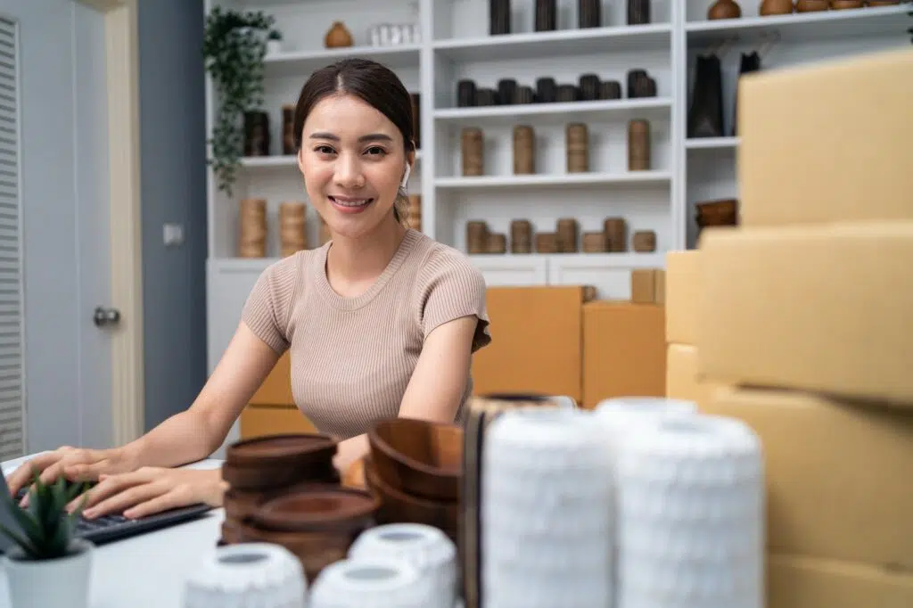 Retrato de mulher asiática vende produtos de vaso on-line e olhando para a câmera.