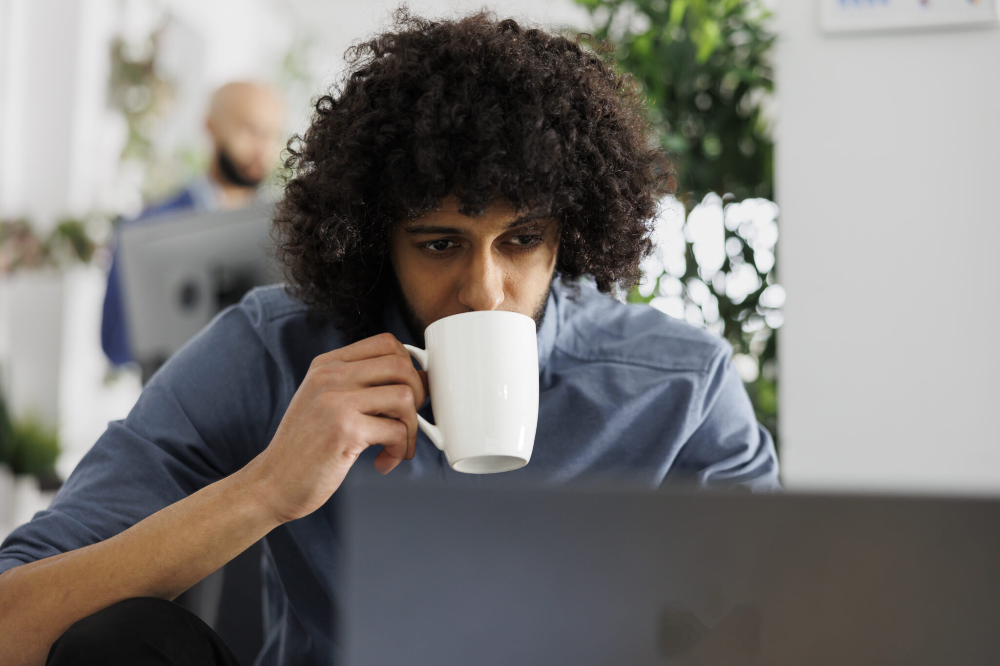 Employee managing seo optimization on laptop while drinking coffee