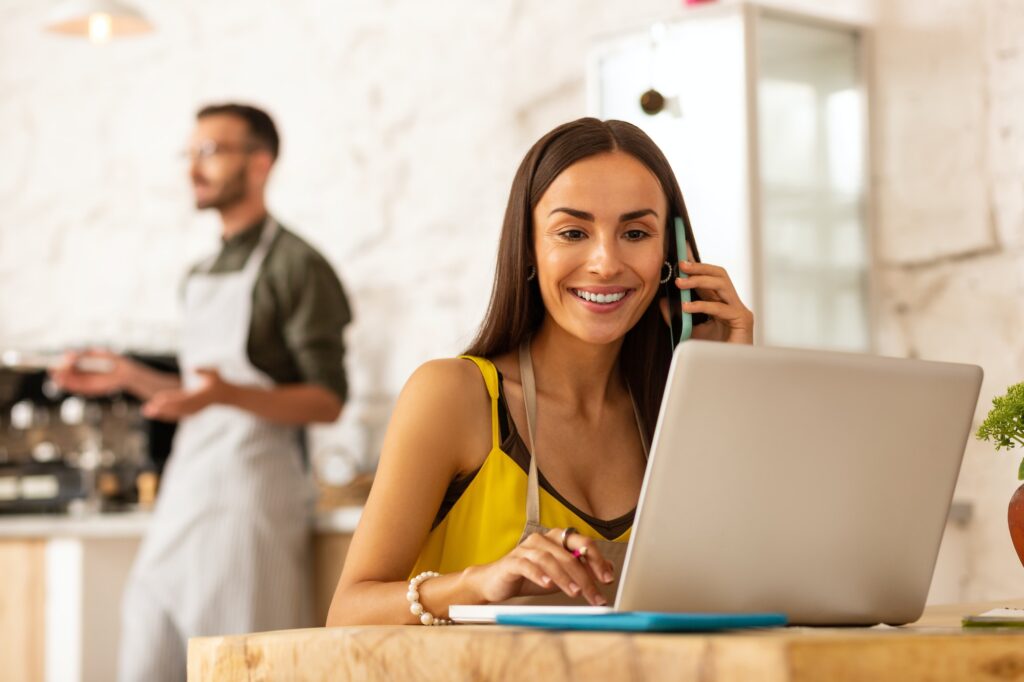 Female entrepreneur sitting near laptop while ordering foods